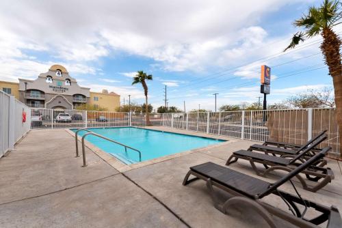 a swimming pool with two chairs and a fence at Comfort Inn & Suites El Centro I-8 in El Centro