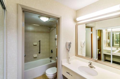 a bathroom with a sink and a toilet and a phone at Econo Lodge Inn & Suites University in Calgary
