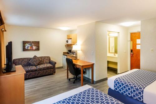 a hotel room with a bed and a couch and a desk at Econo Lodge Inn & Suites University in Calgary