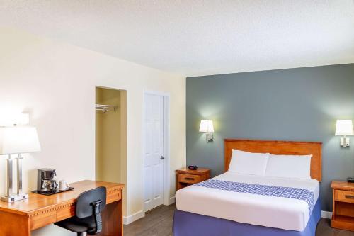a bedroom with a bed and a desk and a bed sidx sidx sidx at Econo Lodge Inn & Suites University in Calgary