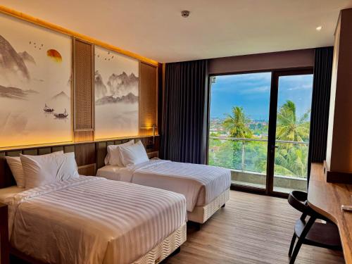 a hotel room with two beds and a large window at Cahaya Villa Garut in Garut