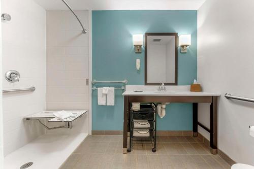 a bathroom with a sink and a mirror at Sleep Inn & Suites Cumberland in Cumberland