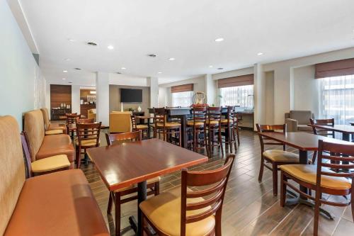 a restaurant with wooden tables and chairs and a bar at Sleep Inn & Suites Cumberland in Cumberland