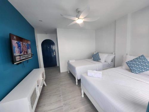 a room with two beds and a couch and a tv at OIA by Seascape in Bauan