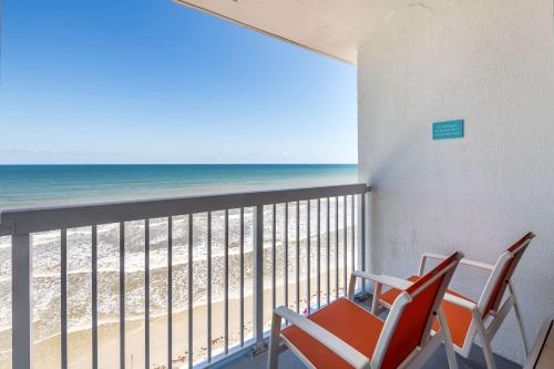a balcony with two chairs and a view of the beach at Comfort Inn & Suites Daytona Beach Oceanfront in Daytona Beach