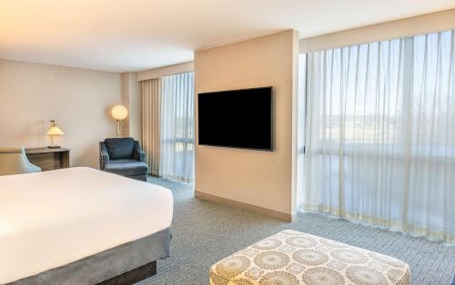 a hotel room with a bed and a flat screen tv at Hilton Richardson Dallas, TX in Richardson