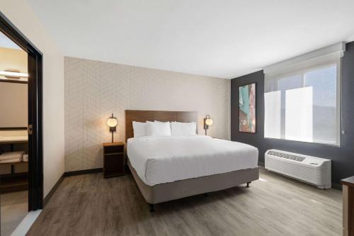 Postel nebo postele na pokoji v ubytování Everhome Suites Corona