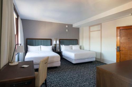 a hotel room with two beds and a desk at Hotel Petersburg, Tapestry Collection By Hilton in Petersburg