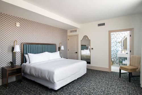 a bedroom with a large white bed and a chair at Hotel Petersburg, Tapestry Collection By Hilton in Petersburg