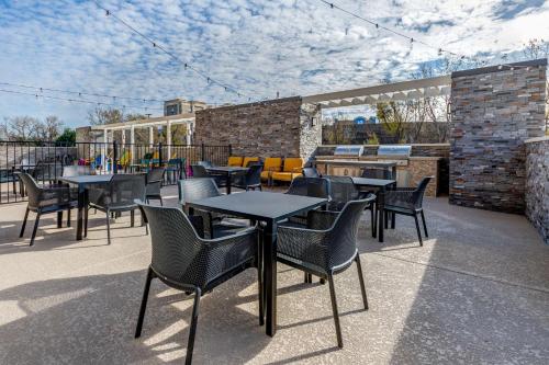 a group of tables and chairs on a patio at Home2 Suites By Hilton Dallas I-30 Cockrell Hill in Dallas