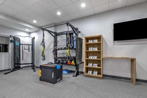 a room with a gym with a tv and equipment at Home2 Suites By Hilton Dallas I-30 Cockrell Hill in Dallas