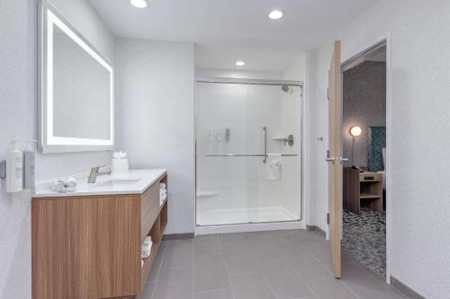 a white bathroom with a sink and a shower at Home2 Suites By Hilton Dallas I-30 Cockrell Hill in Dallas
