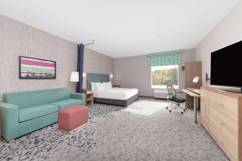 a room with a couch and a bed and a television at Home2 Suites By Hilton Dallas I-30 Cockrell Hill in Dallas