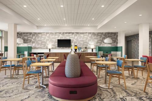 a waiting room with tables and chairs and a couch at Home2 Suites By Hilton San Juan in San Juan