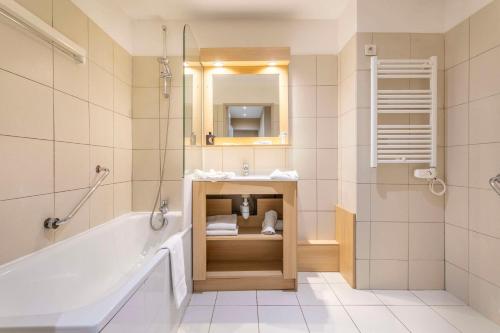 a bathroom with a tub and a sink at Comfort Aparthotel Marseille Prado in Marseille