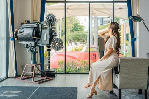 a woman sitting on a chair in front of a camera at Wave Hotel Pattaya in Pattaya Central