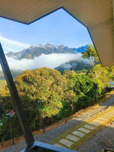 a view from a window of a mountain with clouds at The Pampines Villa, Mount Kinabalu in Ranau