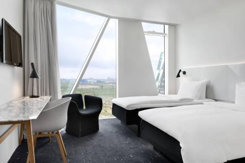 a hotel room with two beds and a window at AC Hotel by Marriott Bella Sky Copenhagen in Copenhagen