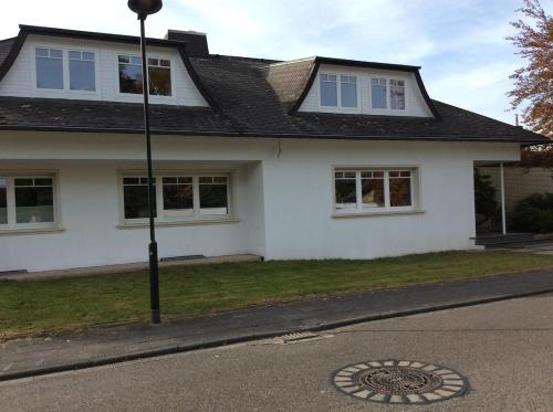 a white house with a manhole in the street at Lovely guest suite in country villa near Cologne in Kerpen