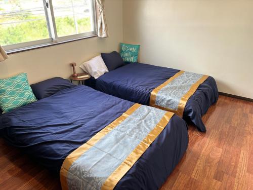 a bedroom with two beds and a couch at The Villa Lino in Yomitan