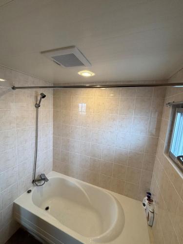a bathroom with a bath tub in a room at The Villa Lino in Yomitan