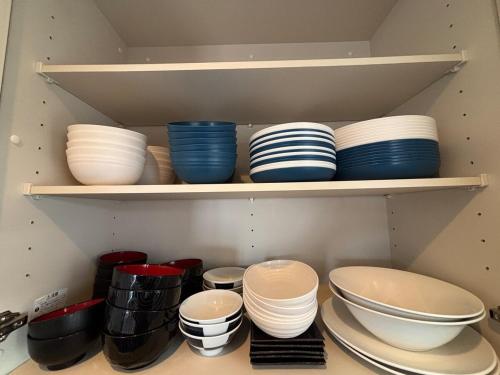 a bunch of bowls and plates on shelves in a kitchen at The Villa Lino in Yomitan
