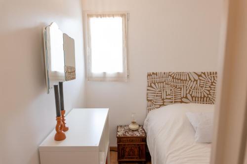 une chambre blanche avec un lit et une fenêtre dans l'établissement La Family - Sleep in La Ciotat, à La Ciotat