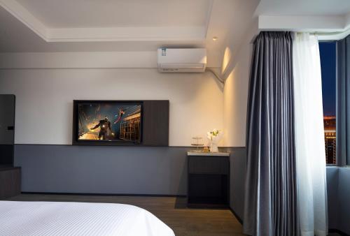 a bedroom with a bed and a tv on a wall at Mcsrh Hotel-Chengdu Hongpailou in Chengdu