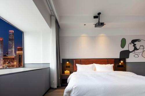 a bedroom with a white bed and a window at Mcsrh Hotel-Chengdu Hongpailou in Chengdu