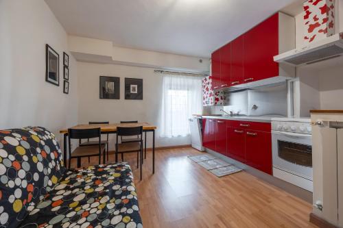 a kitchen with red cabinets and a table with chairs at Appartamento La Bottega del Sarto in Palestrina