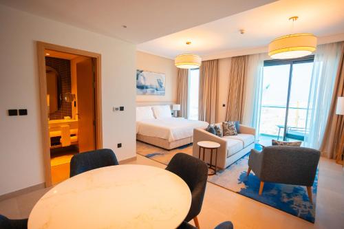 a hotel room with a bed and a table and chairs at Exclusive Residences at Address Marassi Vista in Amwaj Island