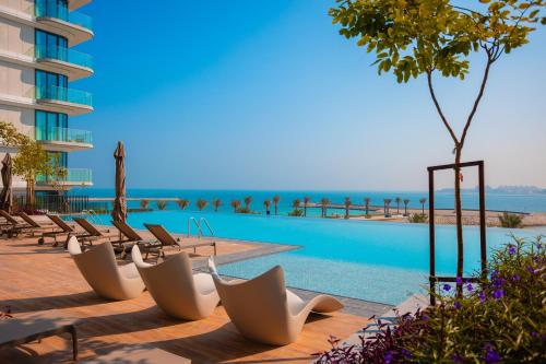 a row of chairs next to a swimming pool at Exclusive Residences at Address Marassi Vista in Amwaj Island