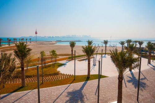 a view of a beach with palm trees and the ocean at Exclusive Residences at Address Marassi Vista in Amwaj Island