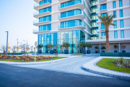 a large building with palm trees in front of it at Exclusive Residences at Address Marassi Vista in Amwaj Island