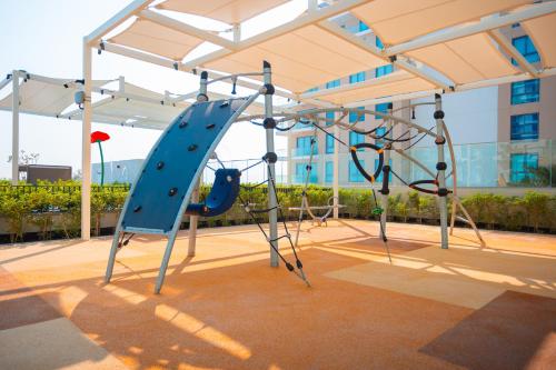 a playground with a blue slide in a building at Exclusive Residences at Address Marassi Vista in Amwaj Island