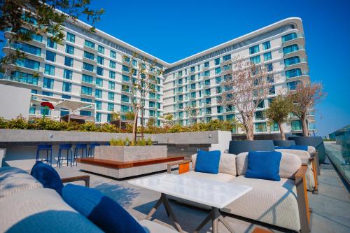 a patio with couches and tables and a large building at Exclusive Residences at Address Marassi Vista in Amwaj Island