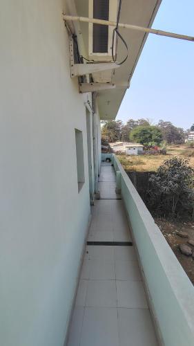 an empty corridor of a building with a balcony at Mahadev Guest House in Dhamtari