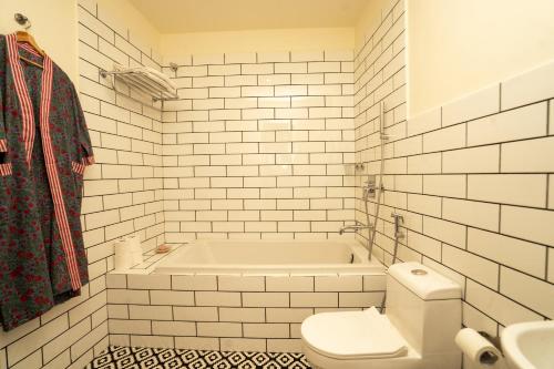 a white bathroom with a tub and a toilet at Aakash Heritage Haveli in Jodhpur