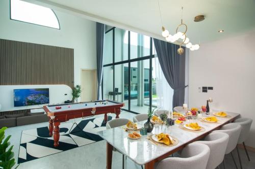 a dining room with a pool table and chairs at Nacha Pool Villa Cha-am in Cha Am