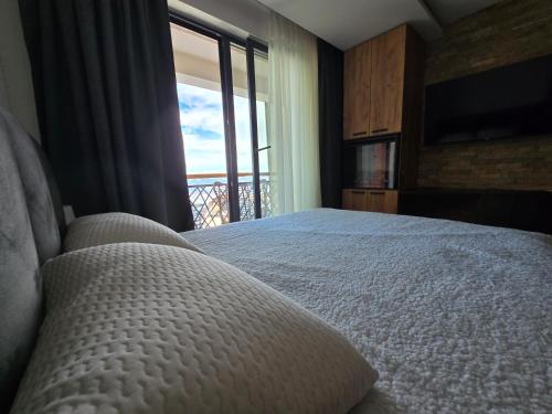 a bedroom with a bed and a large window at VAB Apartments & SPA, Residence hill, Kopaonik in Kopaonik