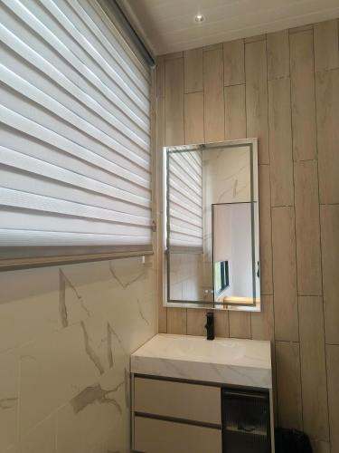 a bathroom with a sink and a mirror at The Pampines Villa, Mount Kinabalu in Ranau