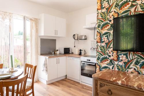 une cuisine avec des armoires blanches et une table et une salle à manger dans l'établissement La Biggy - Sleep in La Ciotat, à La Ciotat