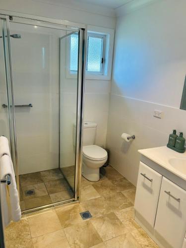 a bathroom with a toilet and a glass shower at Cozy 2-Bedroom Retreat in Young
