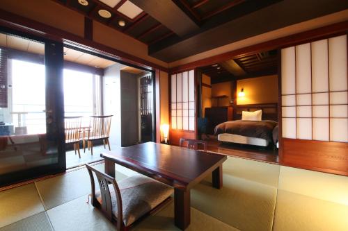 um quarto com uma cama e uma mesa e um quarto em Lakeland Hotel Mizunosato em Fujikawaguchiko