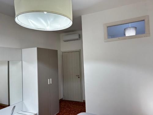 a room with a white wall and a light fixture at BAM BAM TIBURTINA Guesthouse in Rome