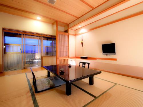 a living room with a table and a tv at Lakeland Hotel Mizunosato in Fujikawaguchiko