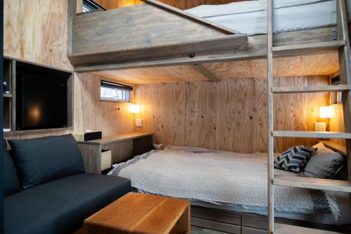 a bedroom with a bunk bed and a couch at HOTEL BOTH in Shari