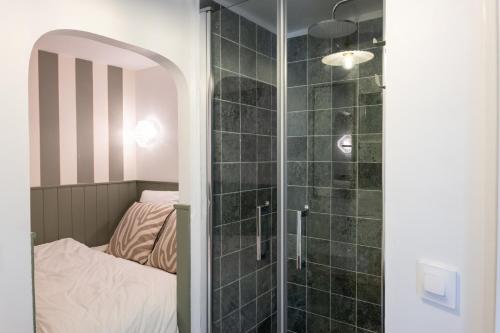 La salle de bains est pourvue d'une douche à l'italienne à côté d'un lit. dans l'établissement La Biggy - Sleep in La Ciotat, à La Ciotat