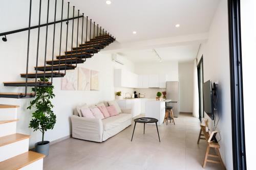 a living room with a white couch and stairs at WealthyStays 2BR Retreat , 5Min Walk to Beach in Protaras