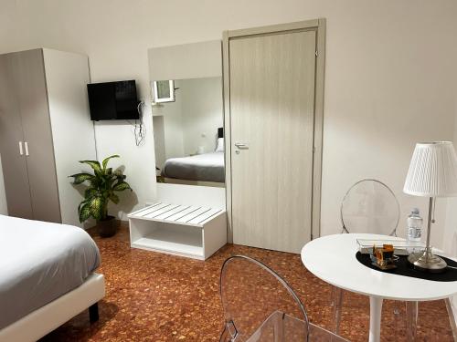 a bedroom with a bed and a table and a mirror at BAM BAM TIBURTINA Guesthouse in Rome